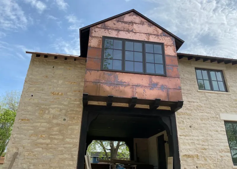 Copper metal panel facade on a stone building for Roof Repair in Spring Arbor